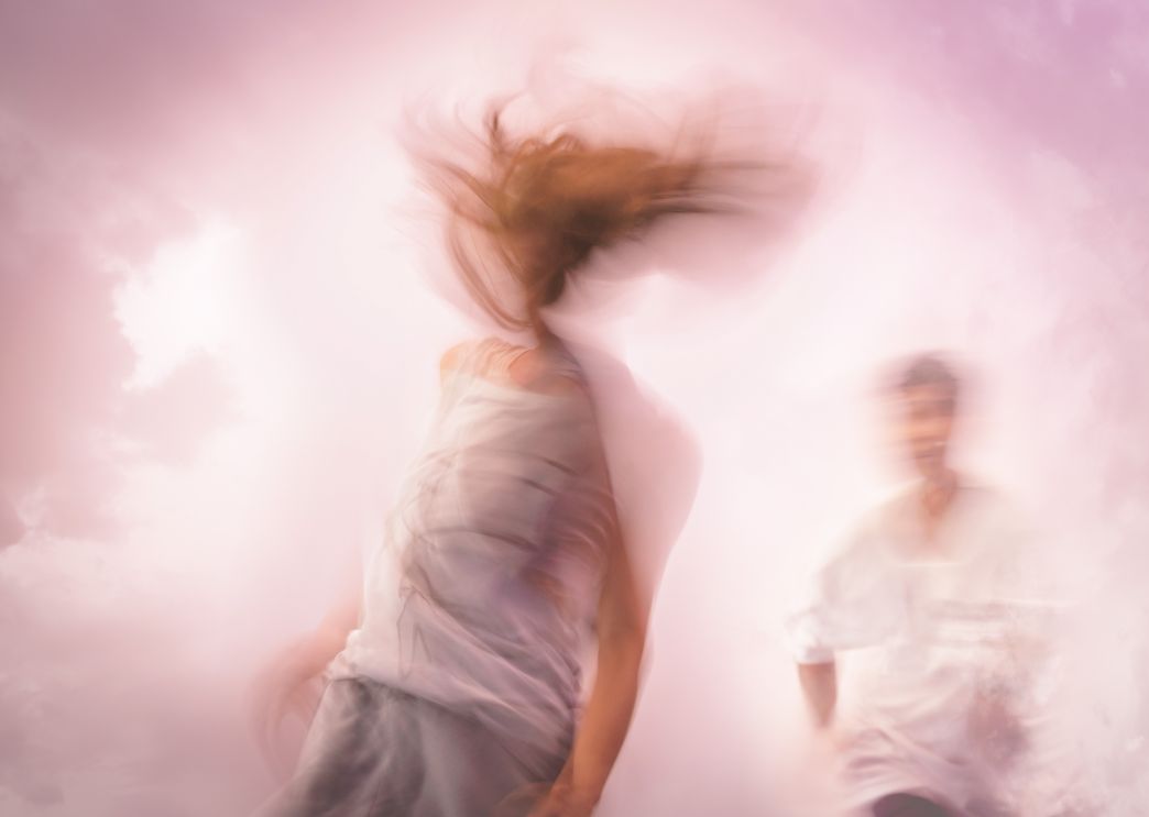 Two dancers moving through a cloud